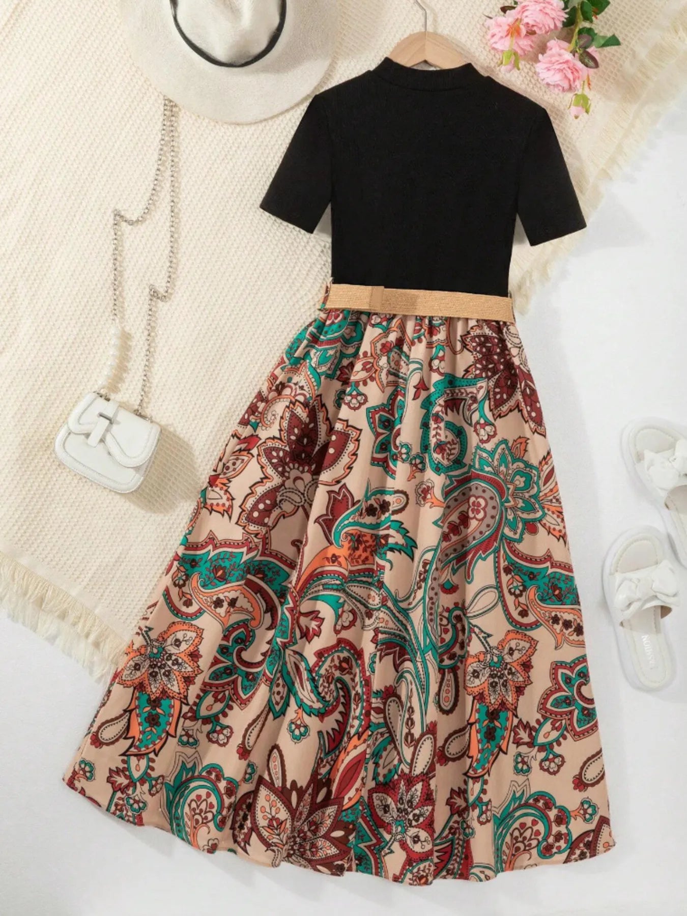 Children's printed short sleeve dress with colorful paisley skirt and black top, featuring a belted waist.